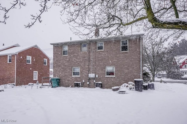 view of snow covered rear of property