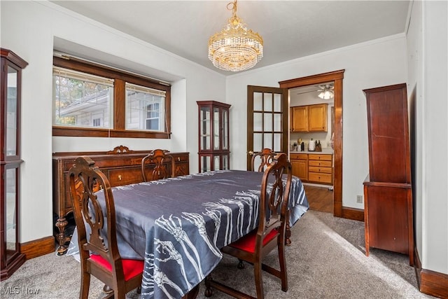 dining space featuring ceiling fan with notable chandelier, ornamental molding, and carpet