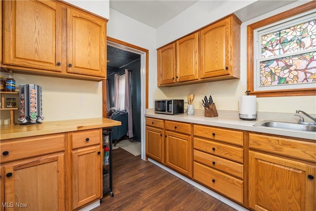 kitchen with sink, dark hardwood / wood-style flooring, and beverage cooler