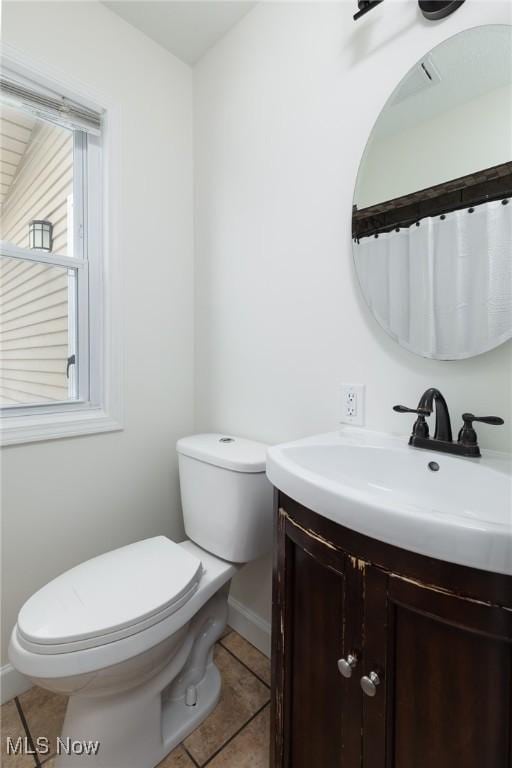 bathroom with tile patterned flooring, vanity, and toilet