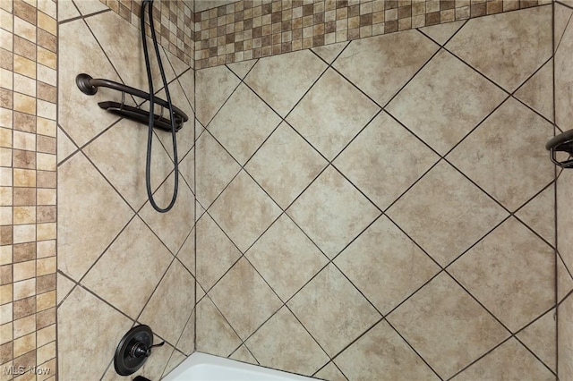 room details with tiled shower / bath combo