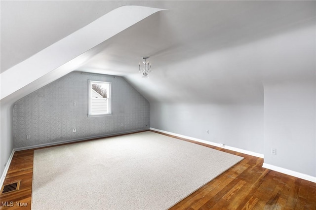 bonus room featuring lofted ceiling and dark hardwood / wood-style floors