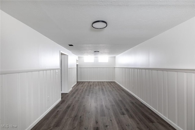 hallway with dark hardwood / wood-style flooring and a textured ceiling