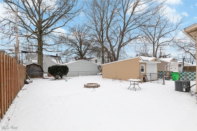 snowy yard with a fire pit and cooling unit