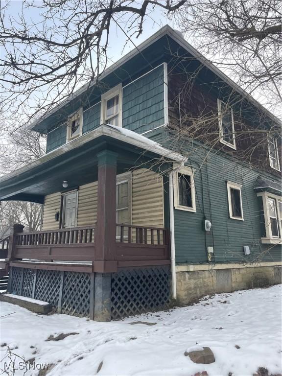 snow covered property featuring covered porch