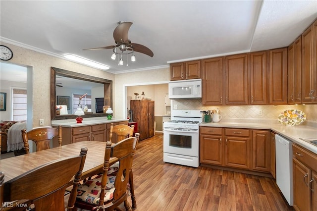 kitchen featuring backsplash, white appliances, ornamental molding, and light hardwood / wood-style floors