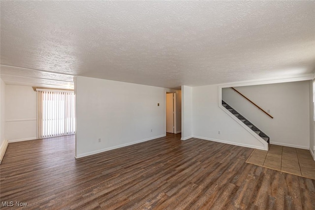 unfurnished living room featuring a textured ceiling and dark hardwood / wood-style flooring