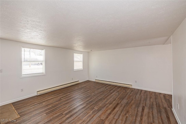 unfurnished room with a textured ceiling, baseboard heating, and dark hardwood / wood-style floors