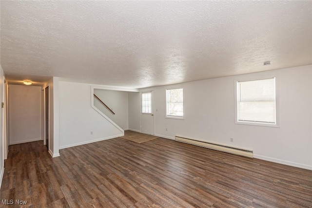 spare room with a textured ceiling, a baseboard radiator, and dark hardwood / wood-style flooring