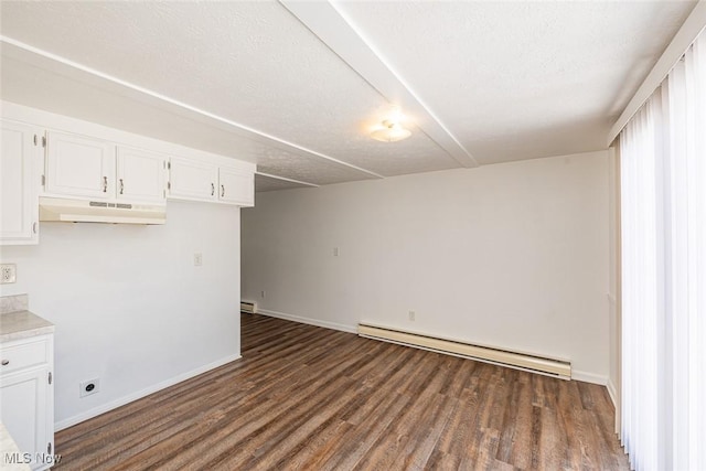 interior space featuring a textured ceiling, dark hardwood / wood-style flooring, and a baseboard heating unit