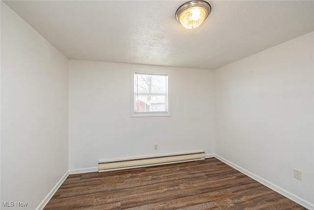 unfurnished room with a textured ceiling, dark hardwood / wood-style flooring, and a baseboard heating unit