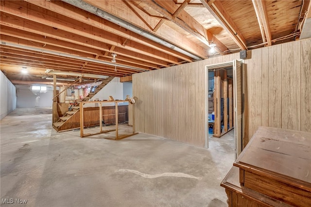 basement featuring wood walls