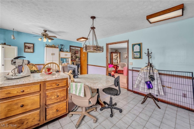 dining space with a textured ceiling, ceiling fan, and light tile patterned floors