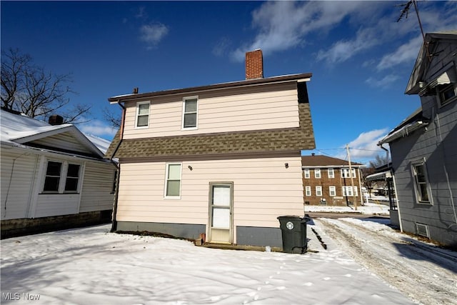 view of snow covered rear of property