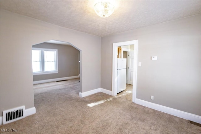 carpeted empty room with a textured ceiling