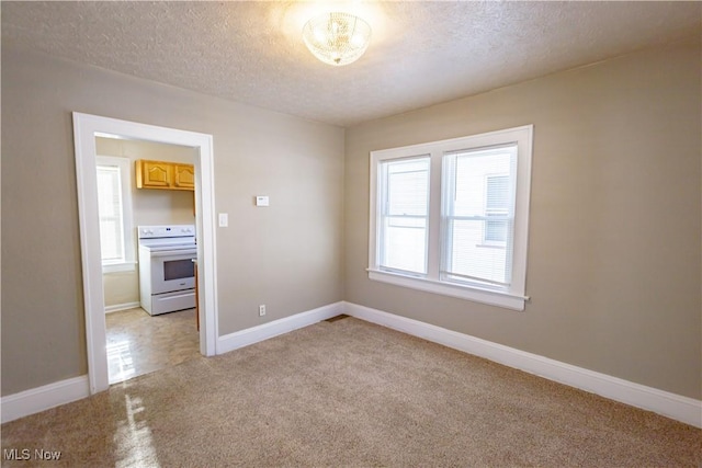 carpeted empty room with a textured ceiling