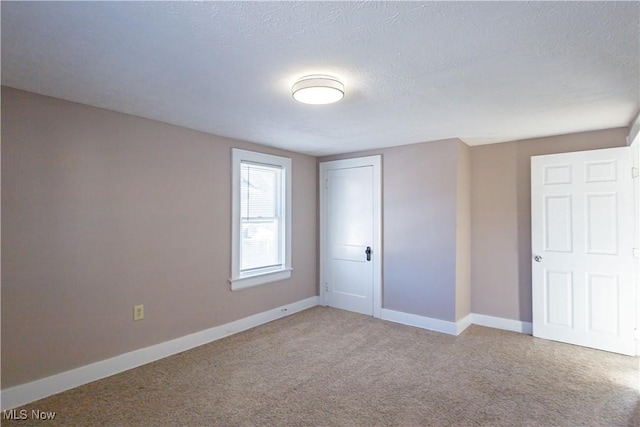 unfurnished bedroom with a textured ceiling, a closet, and light carpet