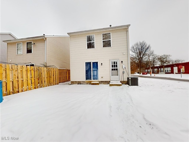 snow covered property featuring central AC unit