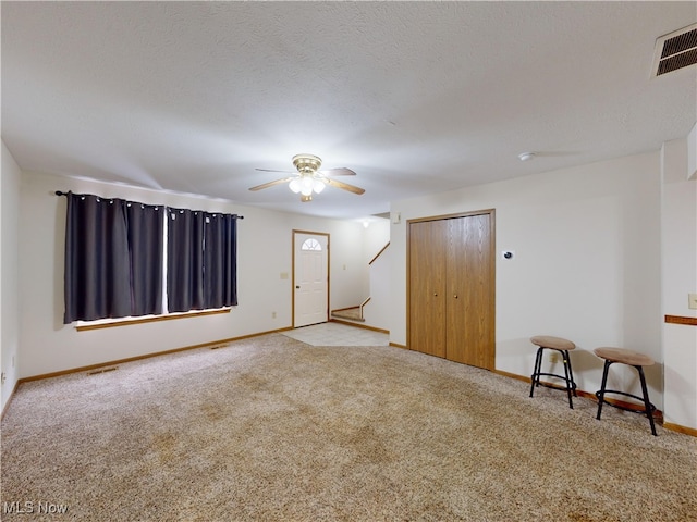 interior space featuring light carpet and ceiling fan