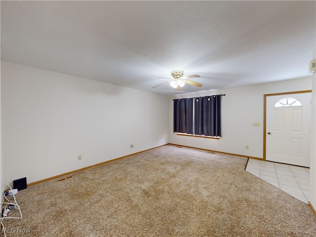 carpeted foyer entrance featuring ceiling fan