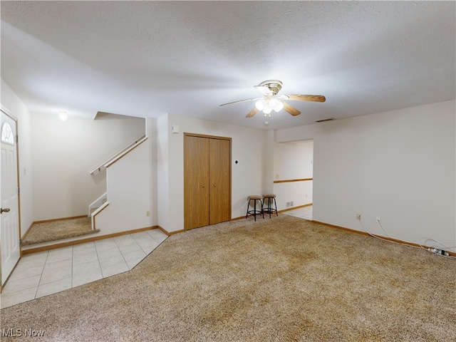 carpeted spare room with ceiling fan and a textured ceiling