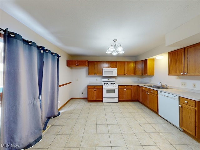 kitchen featuring white appliances, a chandelier, decorative light fixtures, light tile patterned floors, and sink