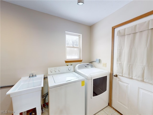 washroom featuring sink, washer and clothes dryer, and light tile patterned floors