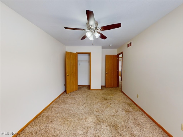 unfurnished bedroom with light colored carpet, ceiling fan, and a closet