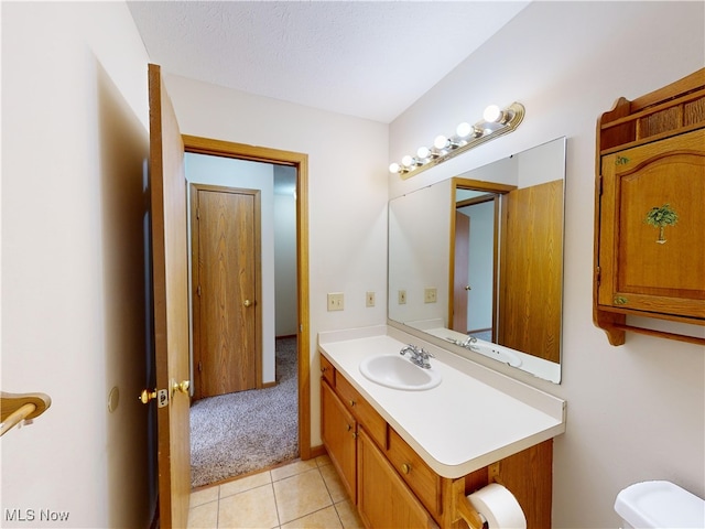 bathroom with vanity, tile patterned flooring, and toilet