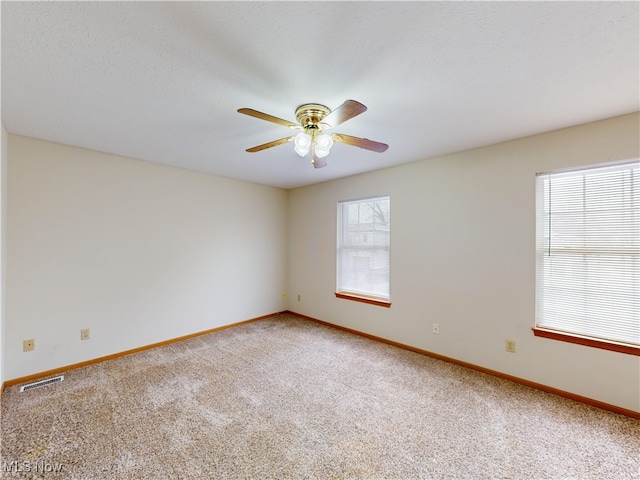 carpeted empty room featuring ceiling fan