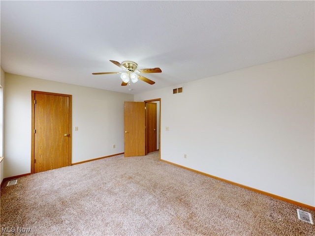 spare room featuring ceiling fan and carpet flooring