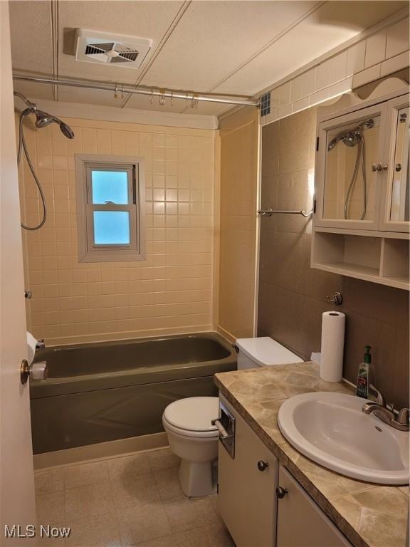 full bathroom with toilet, tiled shower / bath combo, and vanity