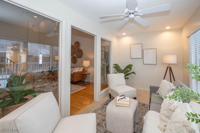 living room featuring ceiling fan, a wealth of natural light, and hardwood / wood-style floors