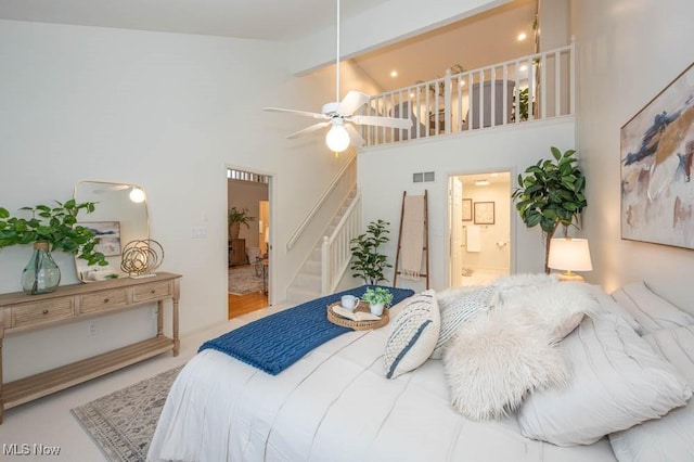 bedroom featuring high vaulted ceiling, ceiling fan, beamed ceiling, and connected bathroom