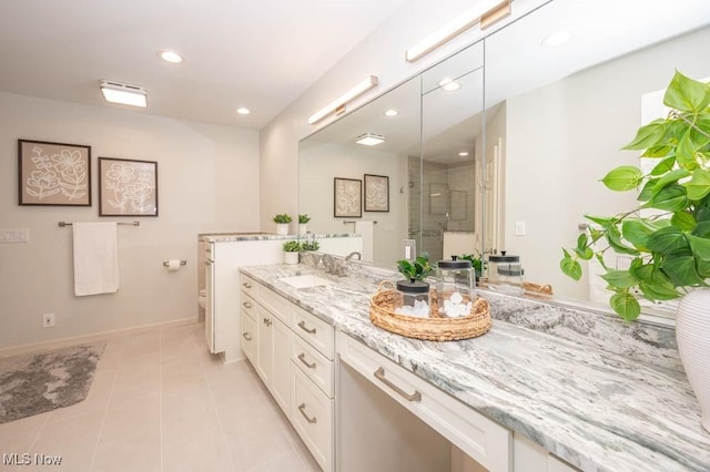 bathroom with vanity, a shower with door, and tile patterned flooring