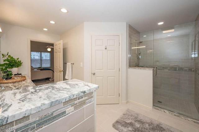 bathroom with an enclosed shower and tile patterned flooring