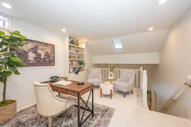 sitting room featuring built in features and vaulted ceiling with skylight