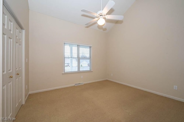 unfurnished bedroom featuring light carpet, a closet, ceiling fan, and vaulted ceiling