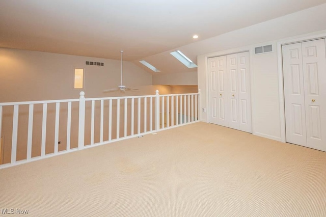 bonus room featuring ceiling fan, lofted ceiling with skylight, and carpet flooring