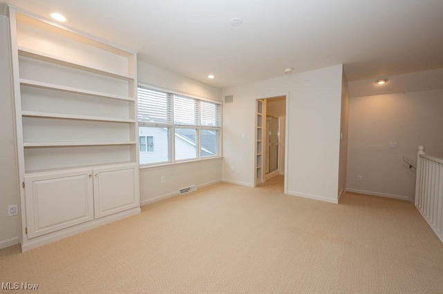 spare room featuring light colored carpet