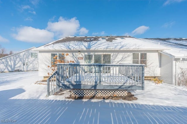 snow covered house featuring a deck