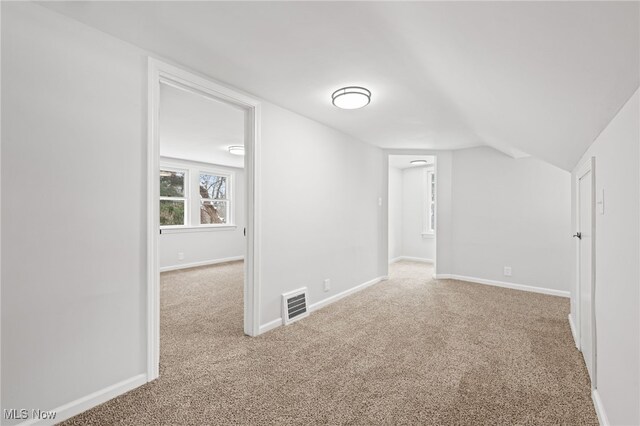 bonus room featuring light colored carpet and lofted ceiling