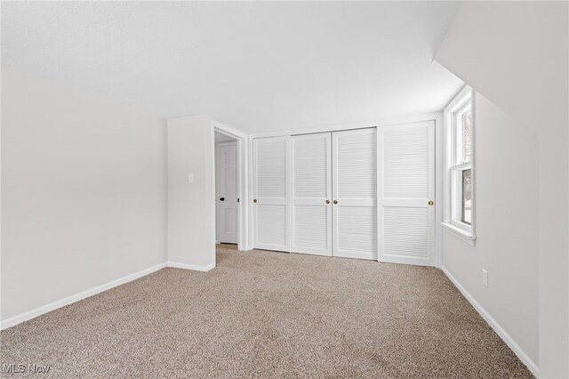 unfurnished bedroom featuring carpet flooring, a closet, and multiple windows