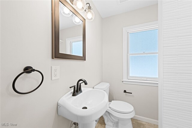 bathroom featuring toilet, tile patterned floors, and sink