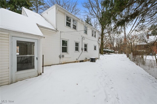 snow covered back of property with cooling unit