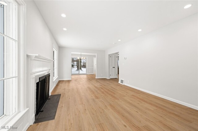 unfurnished living room featuring light hardwood / wood-style floors and an inviting chandelier