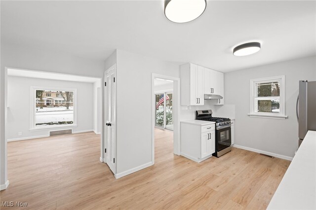 kitchen featuring white cabinets, appliances with stainless steel finishes, and light hardwood / wood-style floors