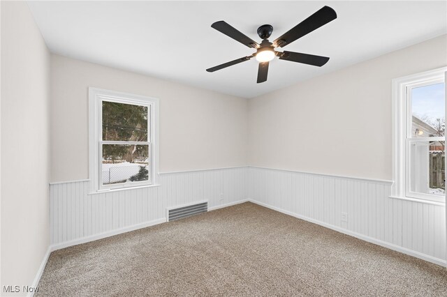 carpeted spare room featuring ceiling fan