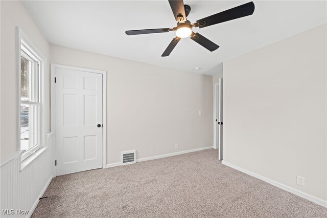 spare room with light carpet and ceiling fan