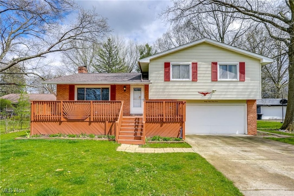 3943 Klein Ave, Stow, OH 44224 - tri-level home with a chimney, concrete driveway, brick siding, a garage, and a front yard
